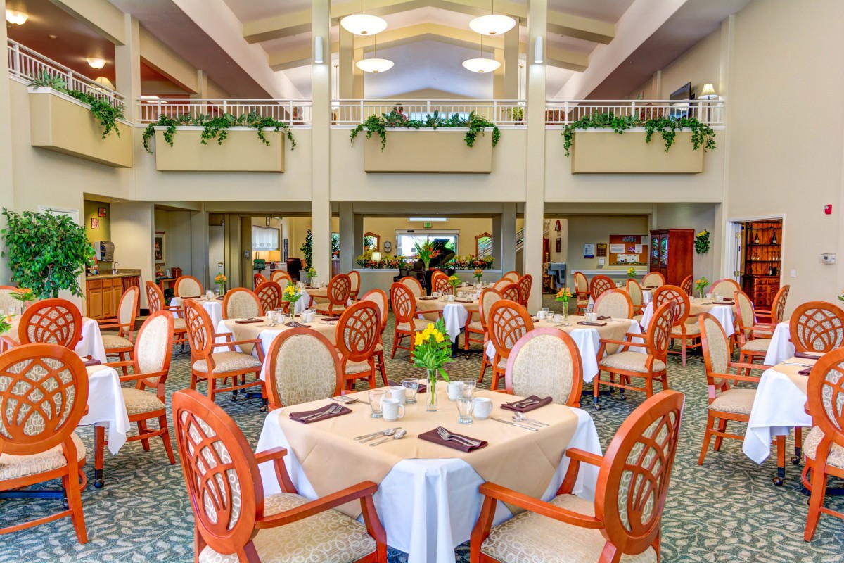 A spacious and elegantly decorated dining room with multiple tables set for a meal.