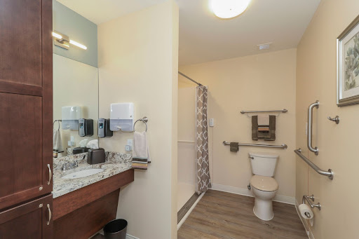 A modern bathroom featuring a shower, toilet, and sink with stylish finishes.