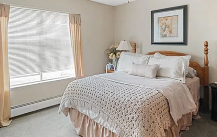 A cozy bedroom with a neatly made bed, soft lighting, and decorative elements.