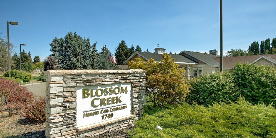 Blossom Creek Community with a prominent entrance sign surrounded by greenery.