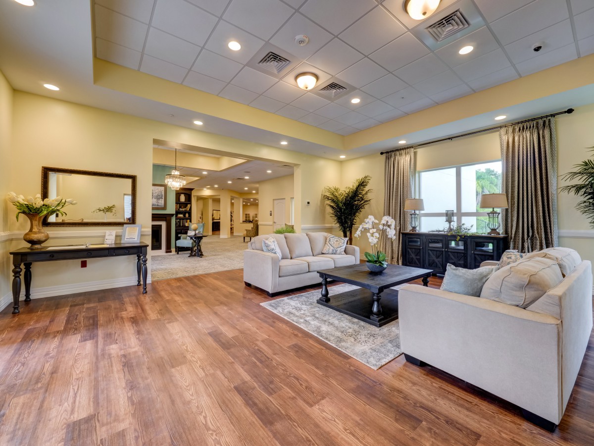 A spacious and modern living room featuring comfortable sofas, wooden flooring, elegant lighting, and tasteful decor.