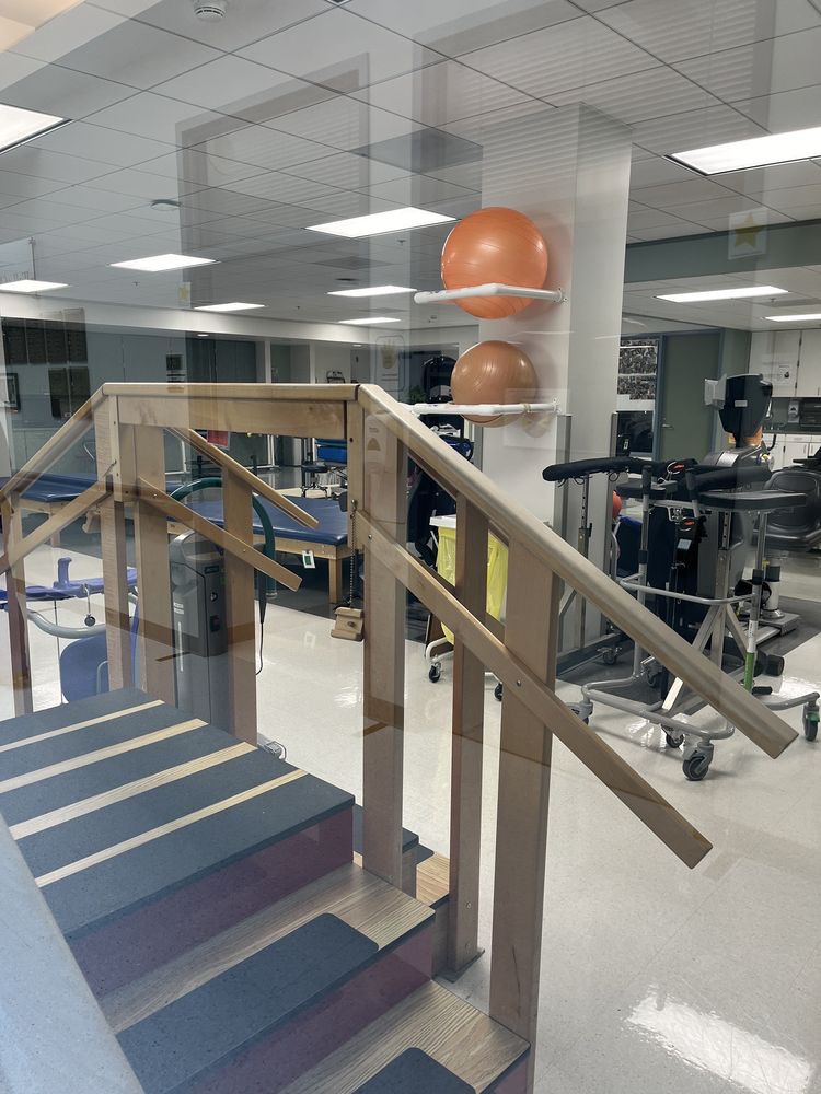 A physical therapy room with exercise equipment, including stairs and fitness tools.