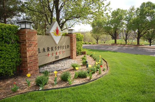A welcoming entrance with a decorative sign and lush landscaping.