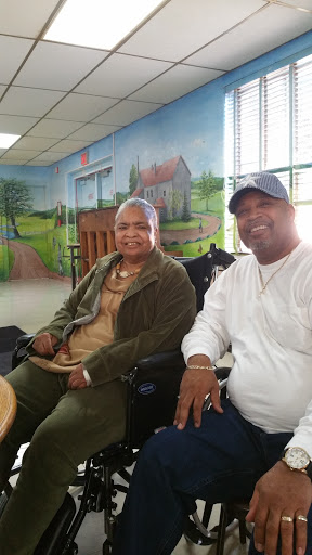 A joyful moment shared between a man and an elderly woman in a community center.
