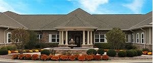 A suburban single-story house with columns and neatly landscaped front yard.