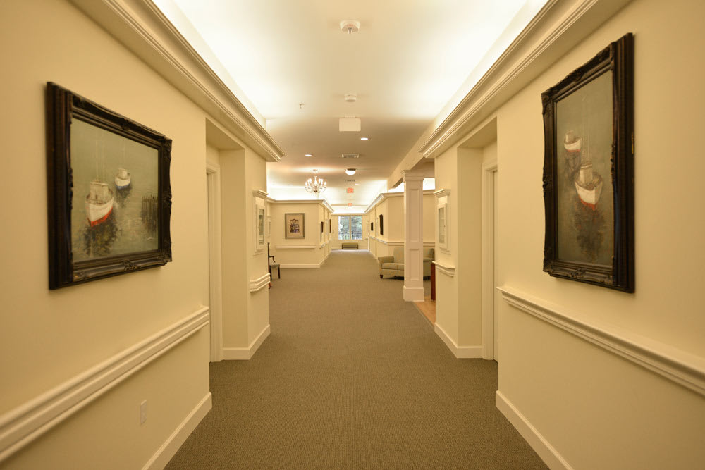 A well-lit hallway adorned with framed artwork on the walls.