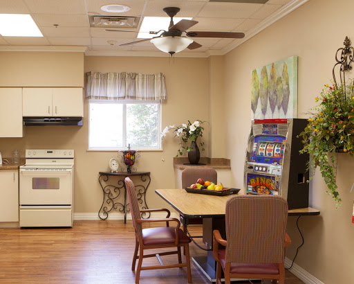 A cozy kitchen and dining area featuring a table with chairs, a ceiling fan, and a vending machine for snacks.