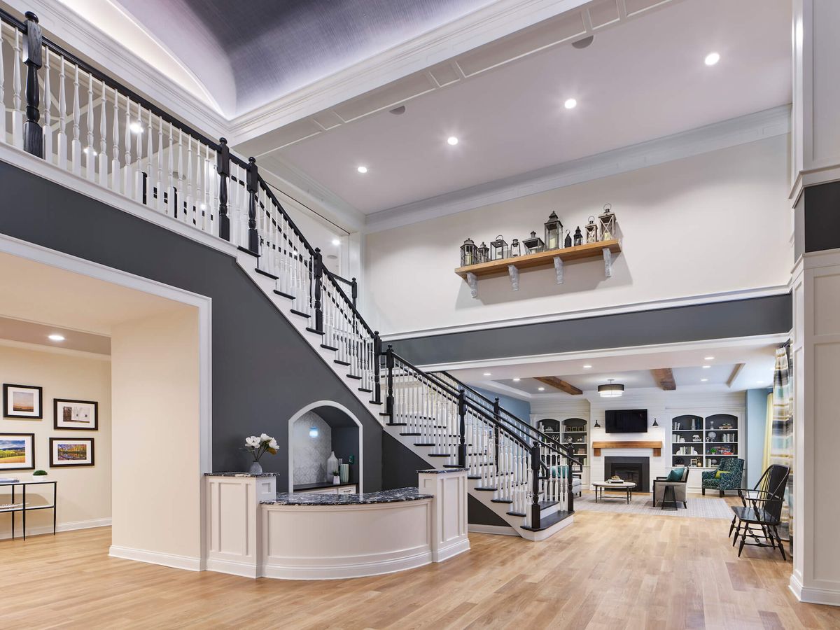 A modern and spacious living room with a stylish staircase leading to an upper level.