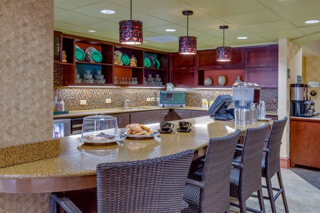 A modern kitchen interior featuring a spacious counter with seating and ambient lighting.
