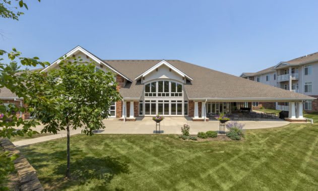 A large, modern house with a well-maintained lawn and elegant architectural design.
