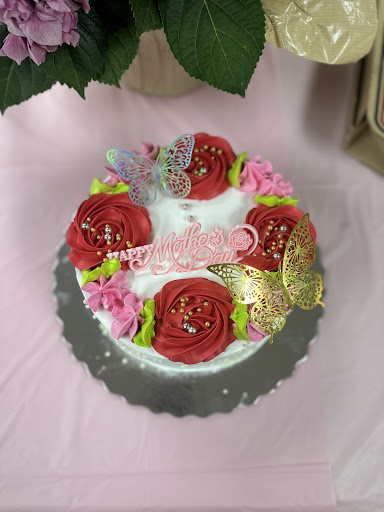 A beautifully decorated cake adorned with roses and butterflies, perfect for a celebration.