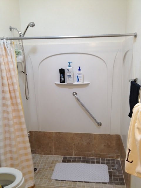A clean and tidy shower area with a grab bar and bathroom essentials.