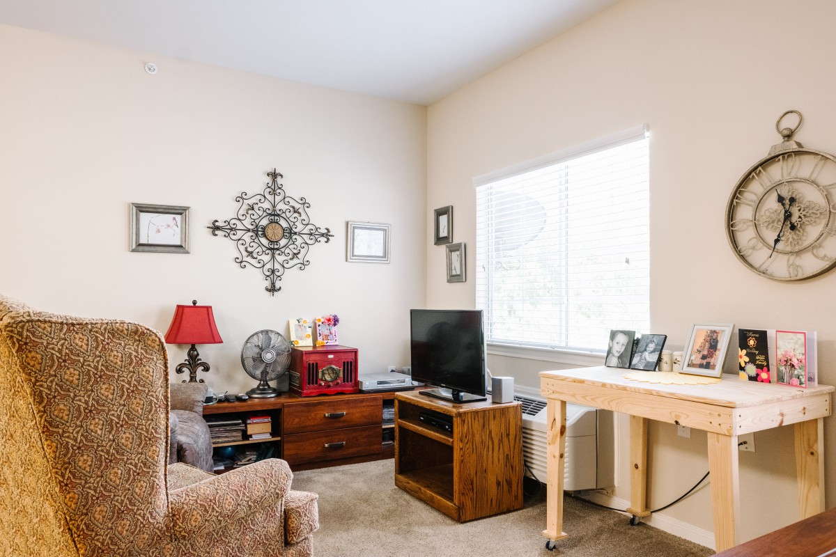 A cozy living room with a TV, comfortable seating, and decorative elements.