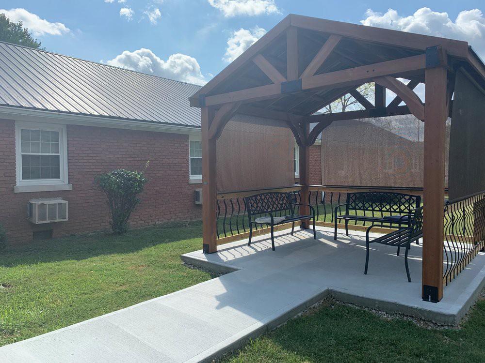 A sunny backyard patio with a gazebo and outdoor furniture.