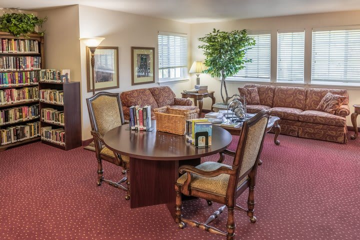 A cozy living room with sofas, a table, books, and warm decor.