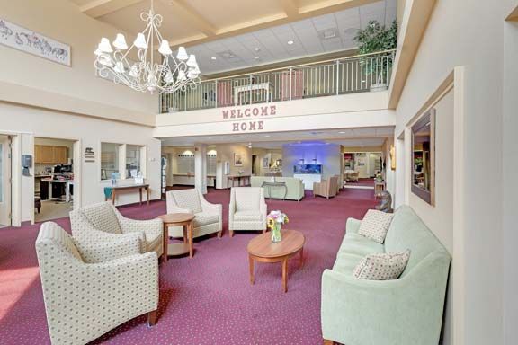 A welcoming lobby area featuring comfortable seating, a chandelier, and a prominent welcome sign.