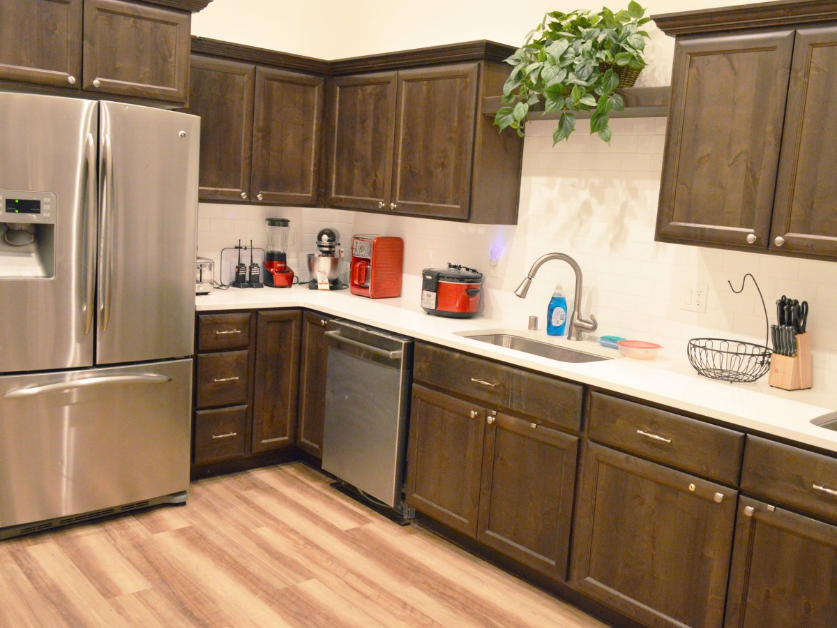 A cozy kitchen with wooden cabinets, stainless steel appliances, and a neatly organized countertop.