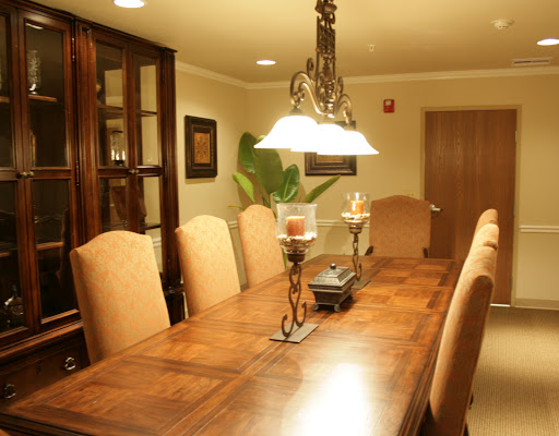 A beautifully arranged dining room featuring a wooden table and upholstered chairs, complemented by elegant lighting.