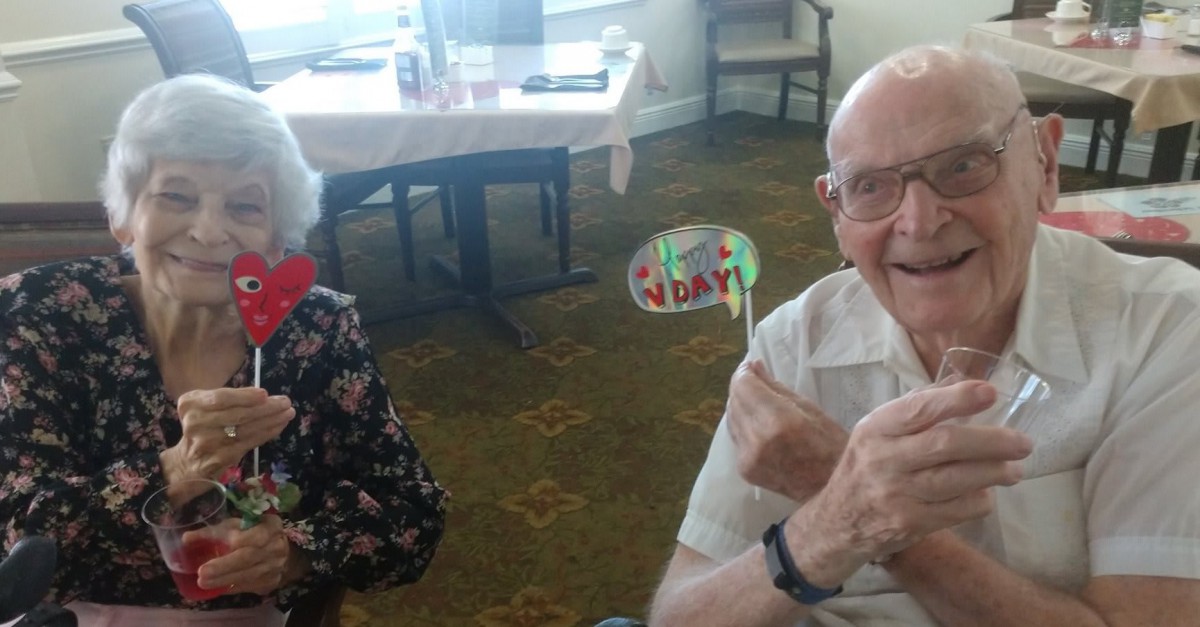 Elderly couple celebrating a birthday indoors.