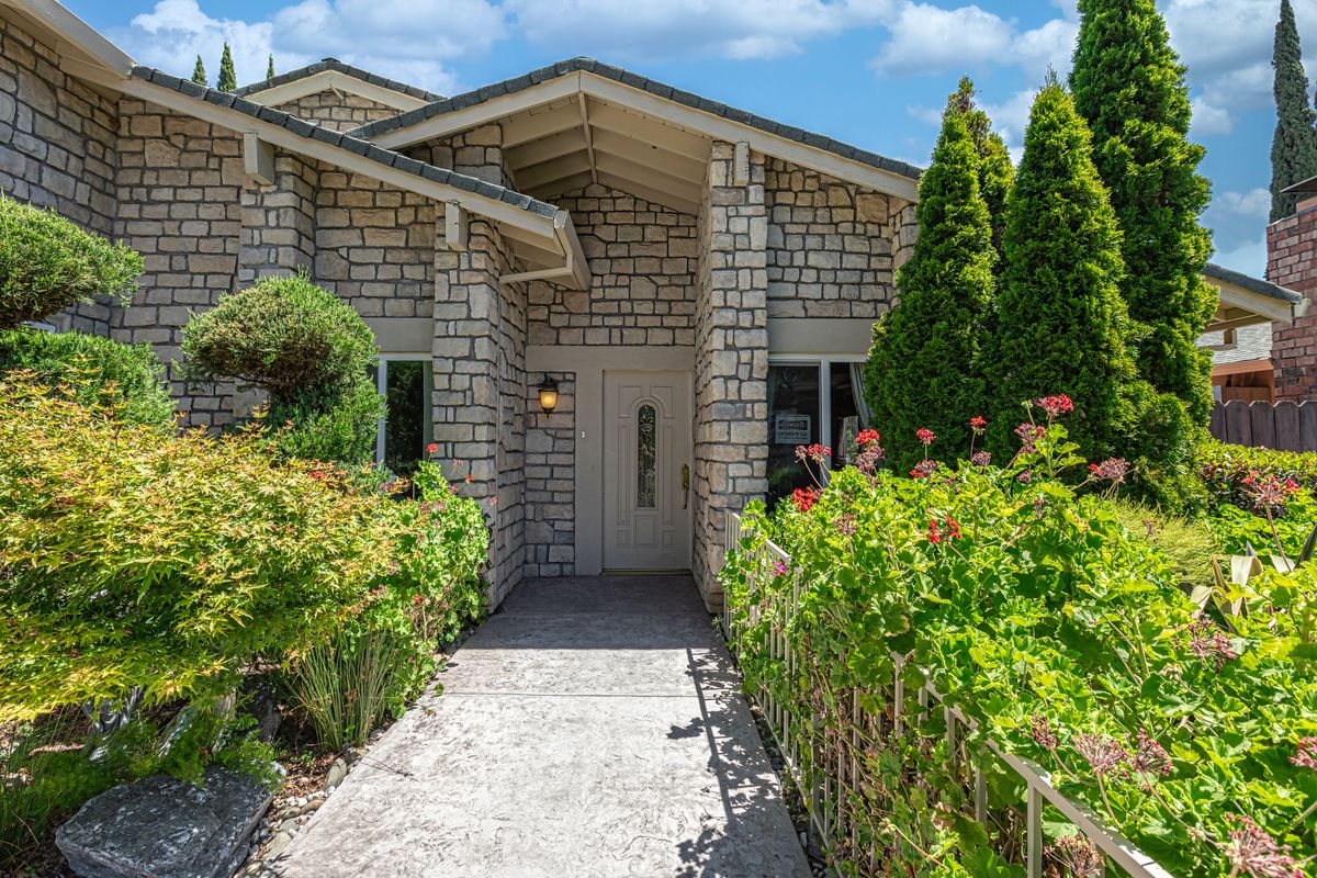 A charming house with a landscaped garden and inviting pathway leading to the entrance.