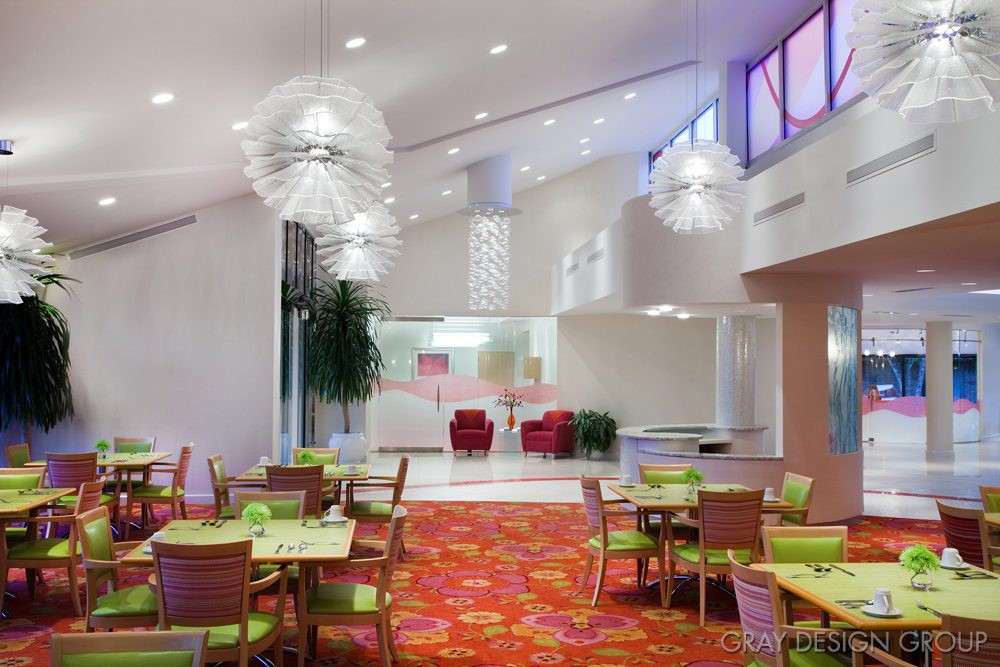 A modern and colorful restaurant interior with eclectic lighting and vibrant decor.