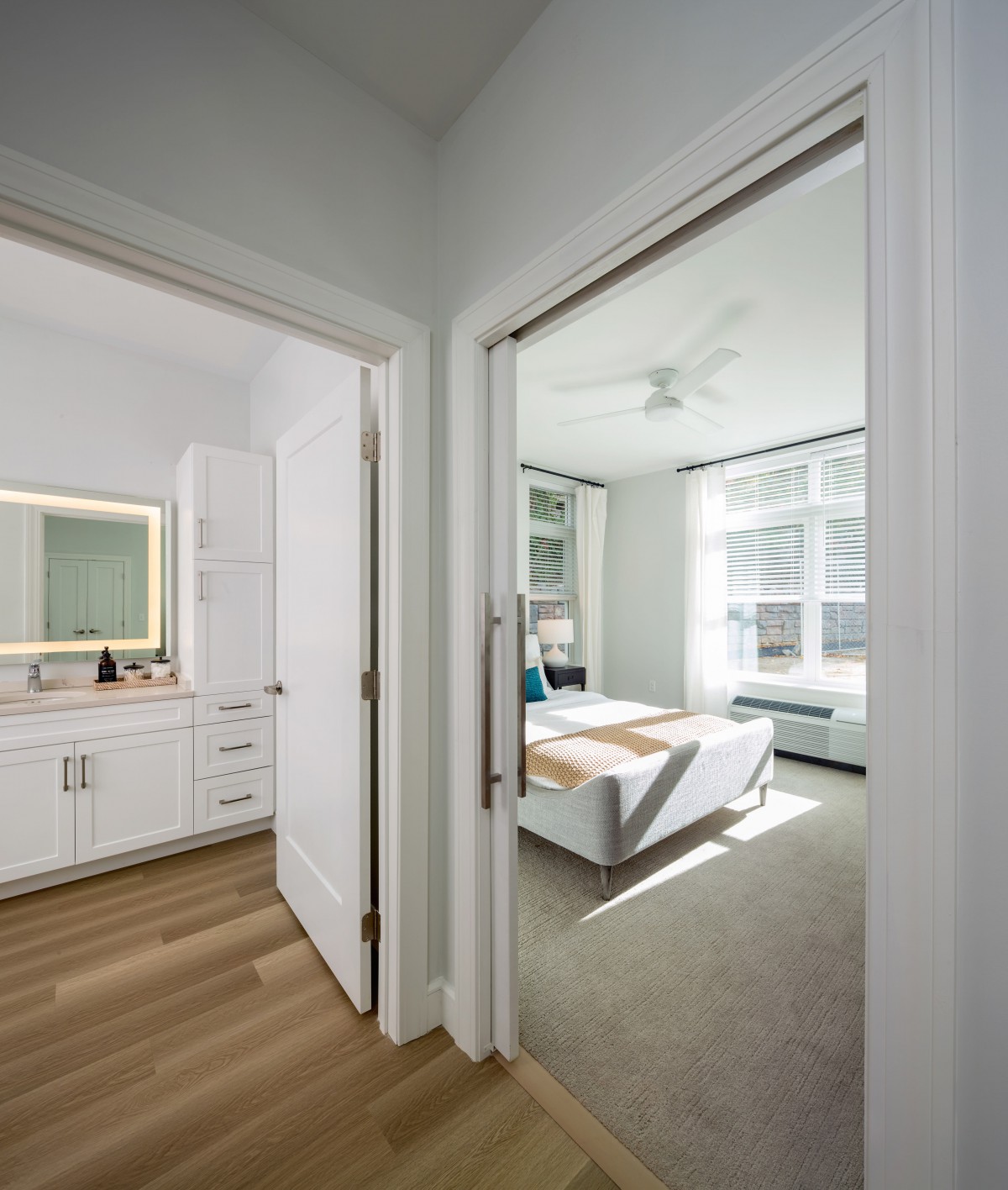 A modern and bright interior featuring a bedroom and bathroom with ample natural light.