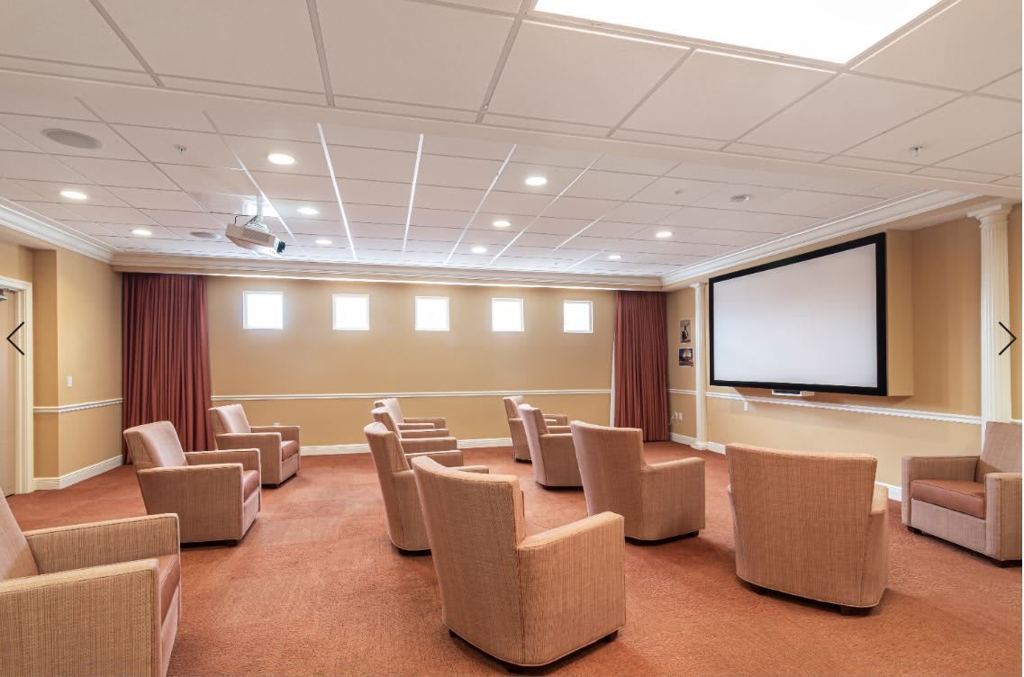 A cozy home theater setup with comfortable chairs and a large projector screen.