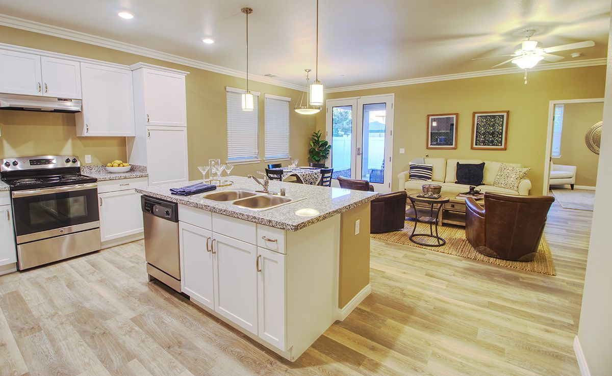 Modern open-concept kitchen and living area with an island and hardwood floors.