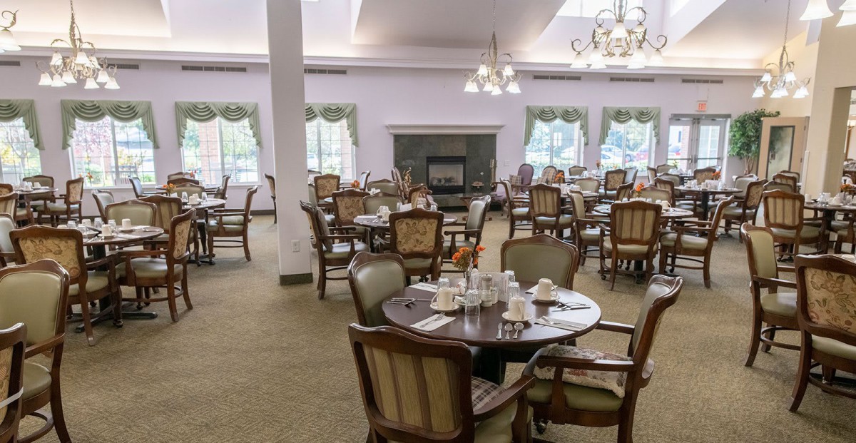 An elegant dining room with multiple tables and chairs set for service.