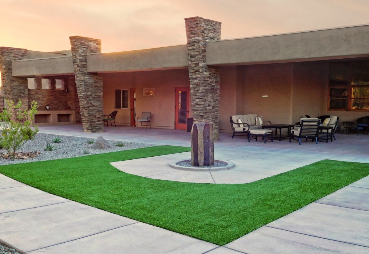 A modern courtyard featuring a central fountain, outdoor seating, and well-maintained landscaping.