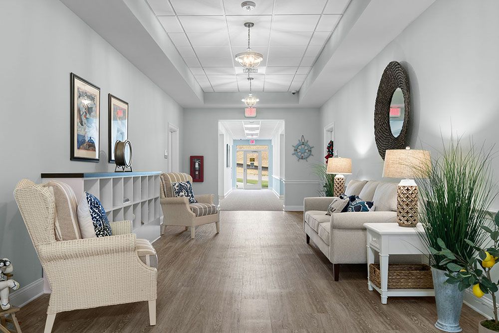 A well-decorated hallway featuring comfortable seating, artwork on the walls, and elegant lighting.