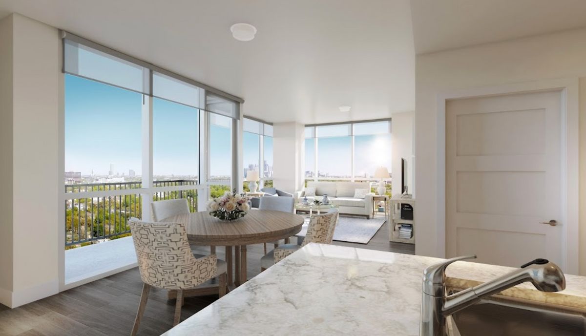 A modern apartment interior with a spacious living and dining area, featuring large windows that allow ample natural light.