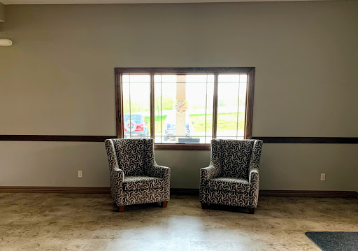 A cozy seating area featuring two patterned chairs placed by a window.
