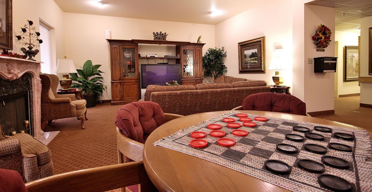 A cozy living room with a checkers board set up on a table.
