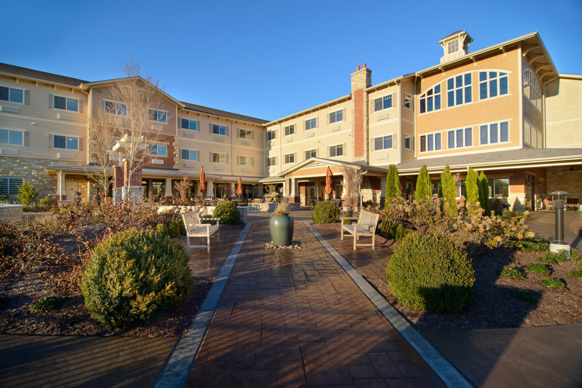 An inviting residential building with landscaped gardens and outdoor seating areas.
