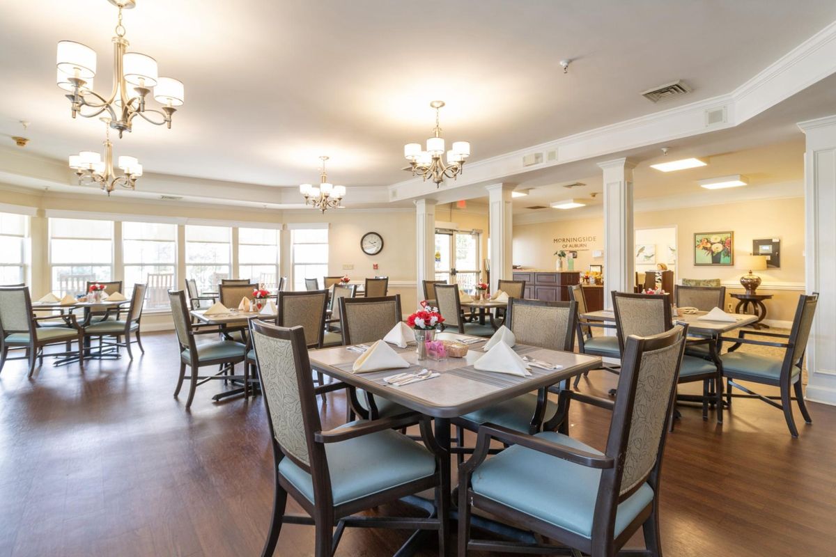 A well-lit dining room with neatly arranged tables and chairs.