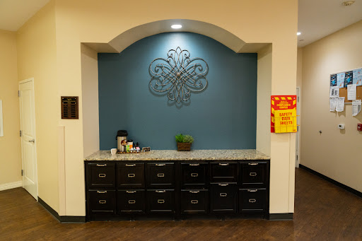 A stylish kitchenette area featuring a blue accent wall and dark cabinetry.