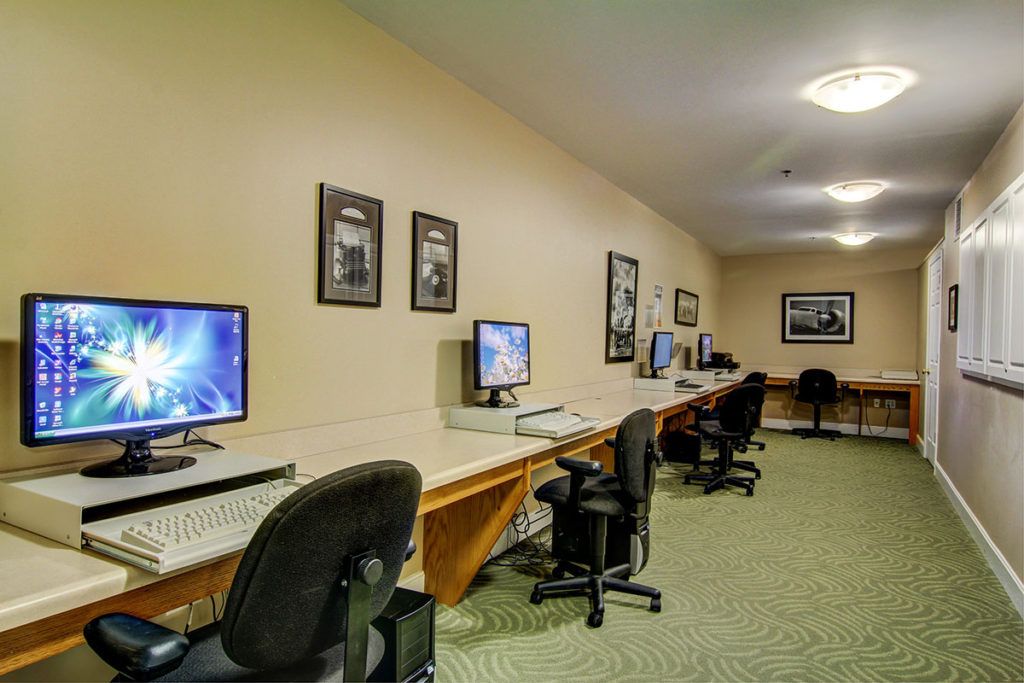 A spacious computer lab with multiple workstations and office chairs.