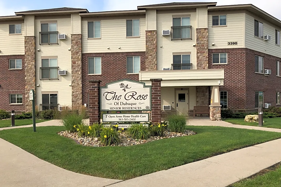 An apartment building with a welcoming entrance and neatly landscaped surroundings.