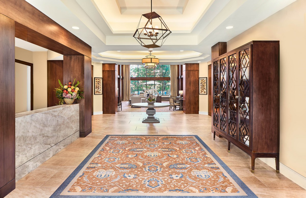 Elegant hotel lobby with intricate decor and chandelier.