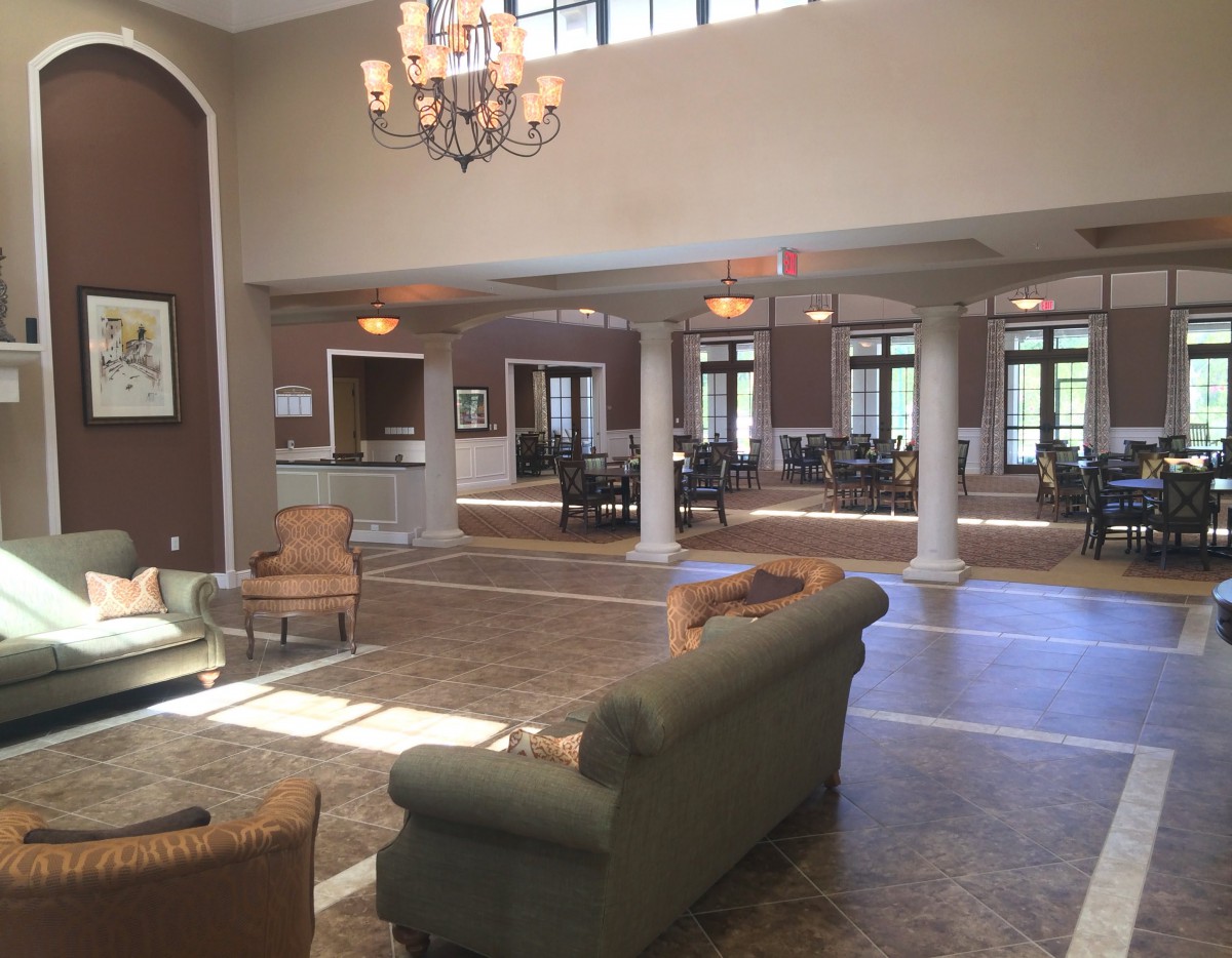 A spacious lobby featuring elegant furniture and a chandelier.