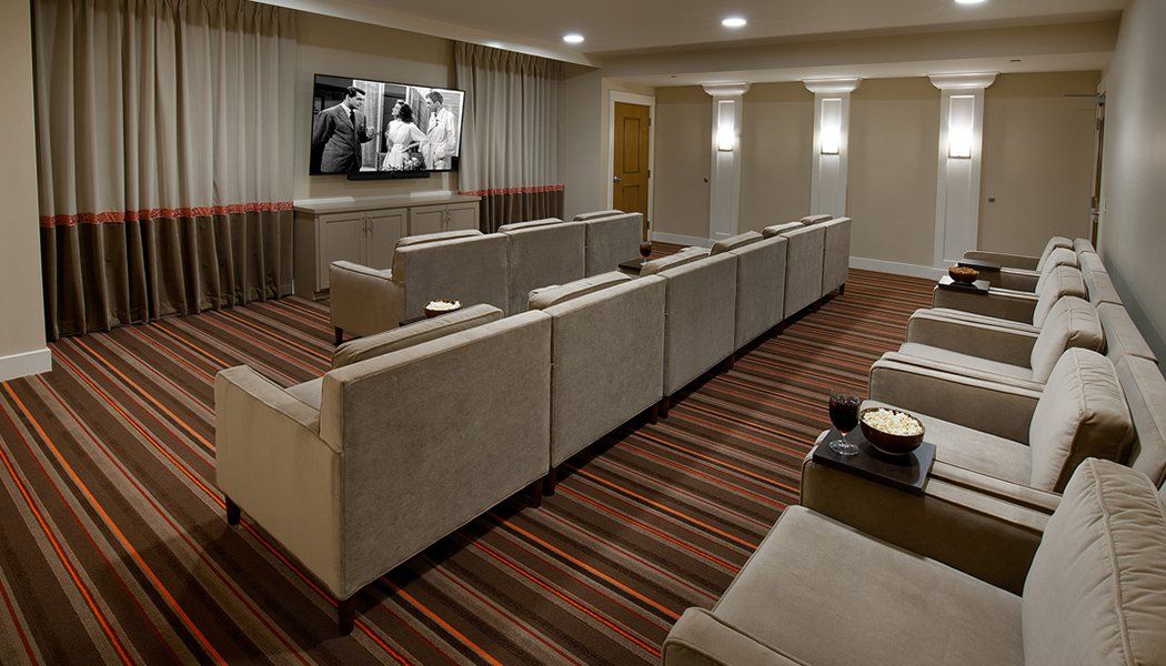A modern home theater with comfortable seating and a large screen TV.