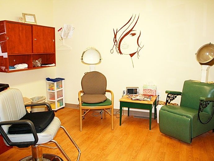 A cozy waiting room with chairs, a table, and wall art.