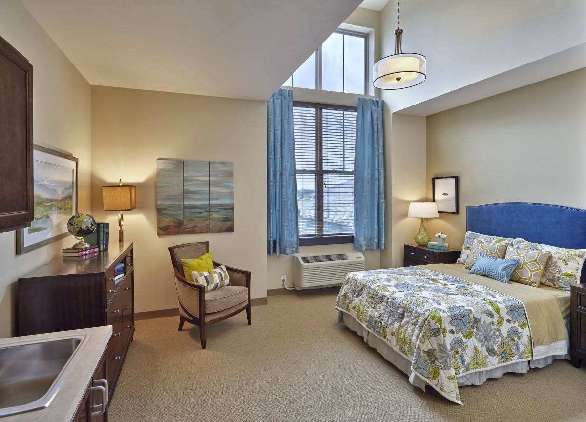 A cozy bedroom with modern decor, featuring a large window, comfortable bed, and stylish furniture.