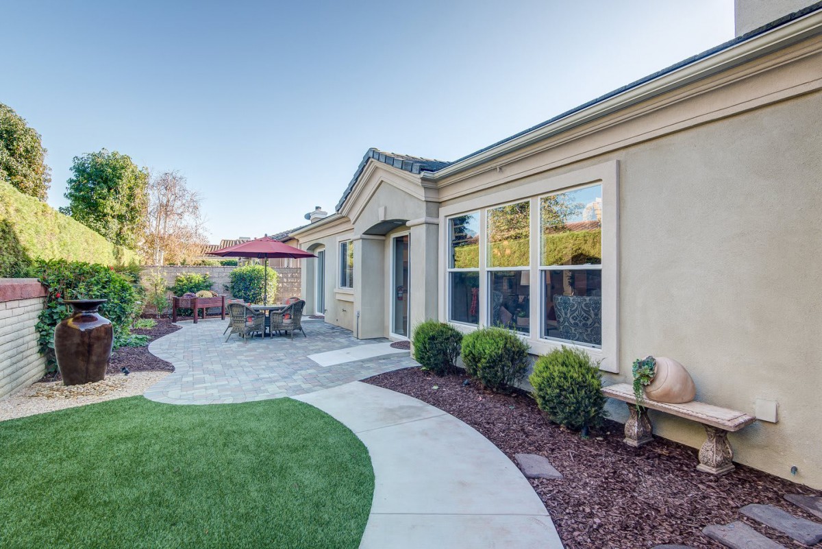 A well-maintained backyard featuring a patio with outdoor furniture and a landscaped garden.