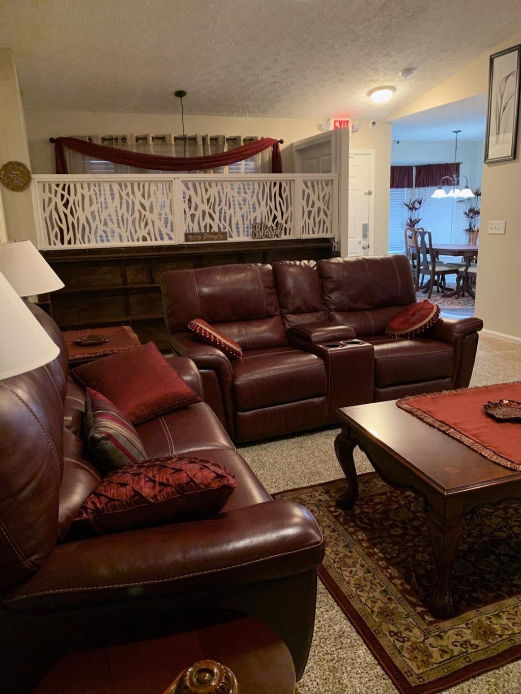 A cozy living room featuring leather sofas, a wooden coffee table, and warm decorative accents.