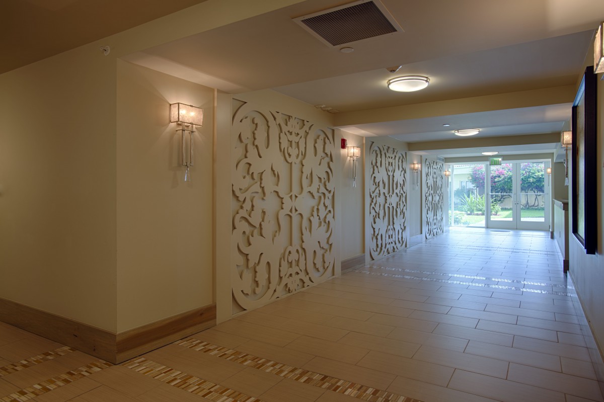A modern hallway featuring decorative wall panels and soft lighting.