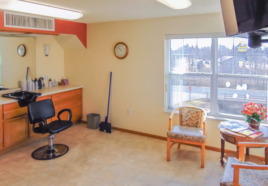 A bright salon interior with a hairdressing station and seating area.