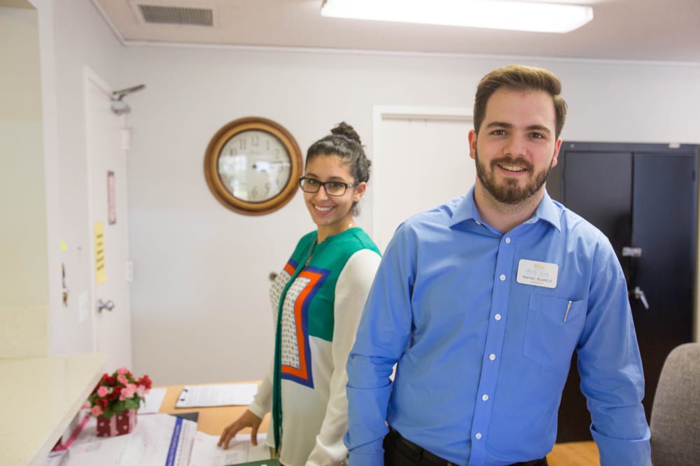Two people smiling in an office environment.