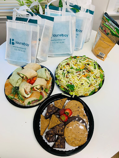 A colorful assortment of lunch options including wraps, salad, and cookies.